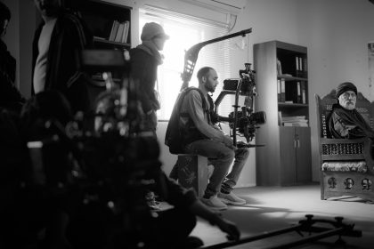Equipe de filmagem trabalha em ambiente interno com uma câmera profissional.
