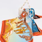 Lenço de seda estampado e colorido sobre uma bolsa de luxo.