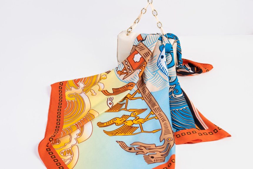 Lenço de seda estampado e colorido sobre uma bolsa de luxo.
