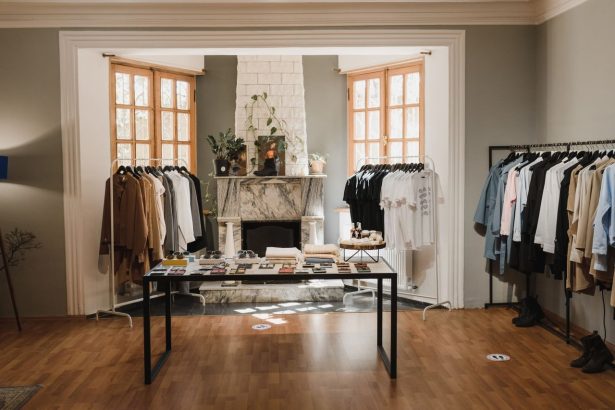 Interior de uma boutique de moda com roupas organizadas em araras e elementos de exposição.